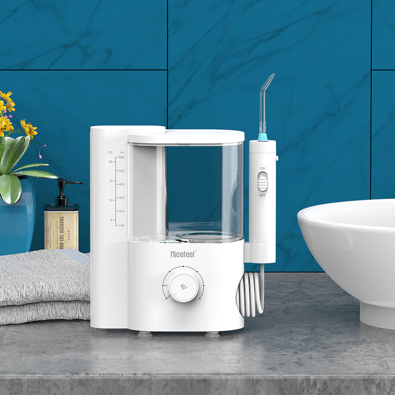 Nicefeel countertop white dental water flosser on a bathroom counter with a blue tiled wall background.